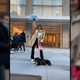 A woman poses with her dog in front of the G/O Media offices in New York City.